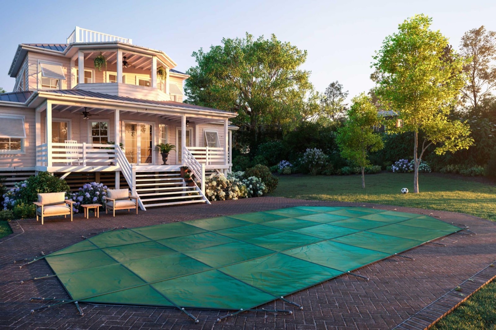 A grecian pool under a green safety cover at dusk