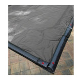 Solid winter cover installed over a rectangular inground pool