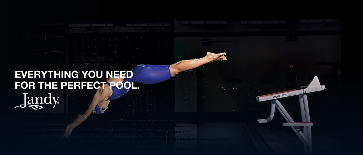 A swimmer diving from the blocks in a dark pool. Everything you need for the perfect pool. Jandy