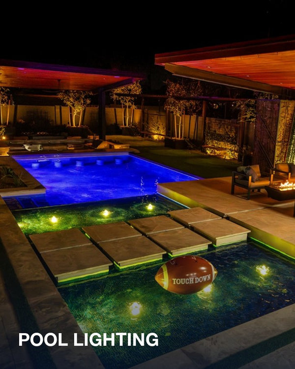 Pool lighting: a backyard pool and spa lit in blue and green at night