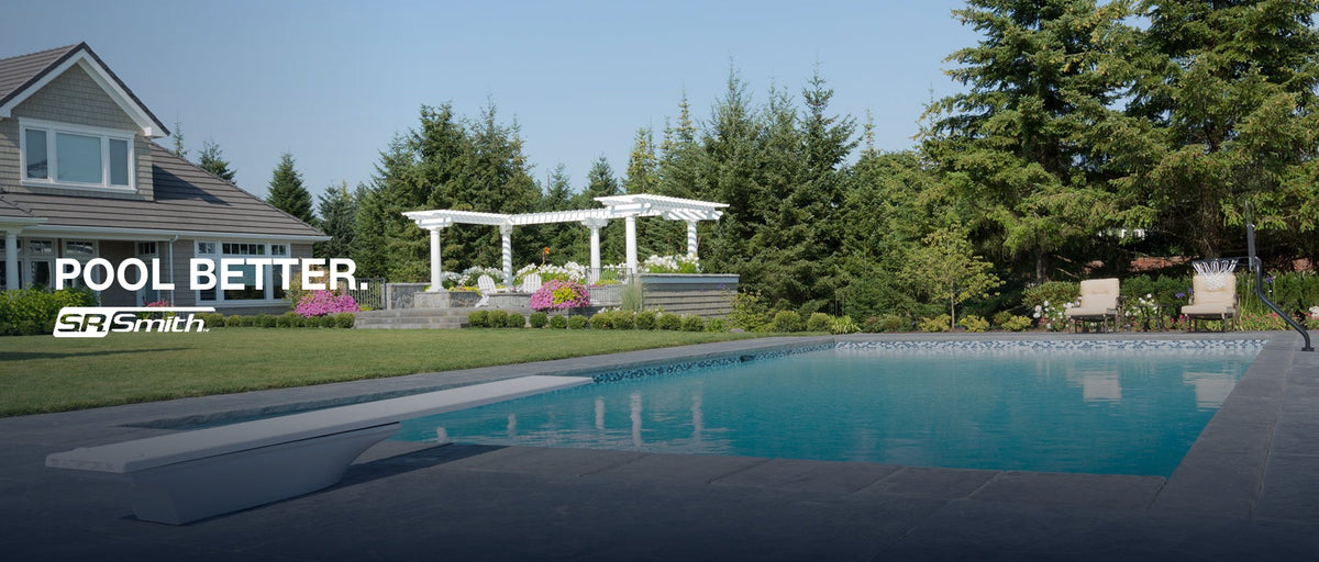 A white diving board at the edge of a backyard pool. Pool better. S.R. Smith