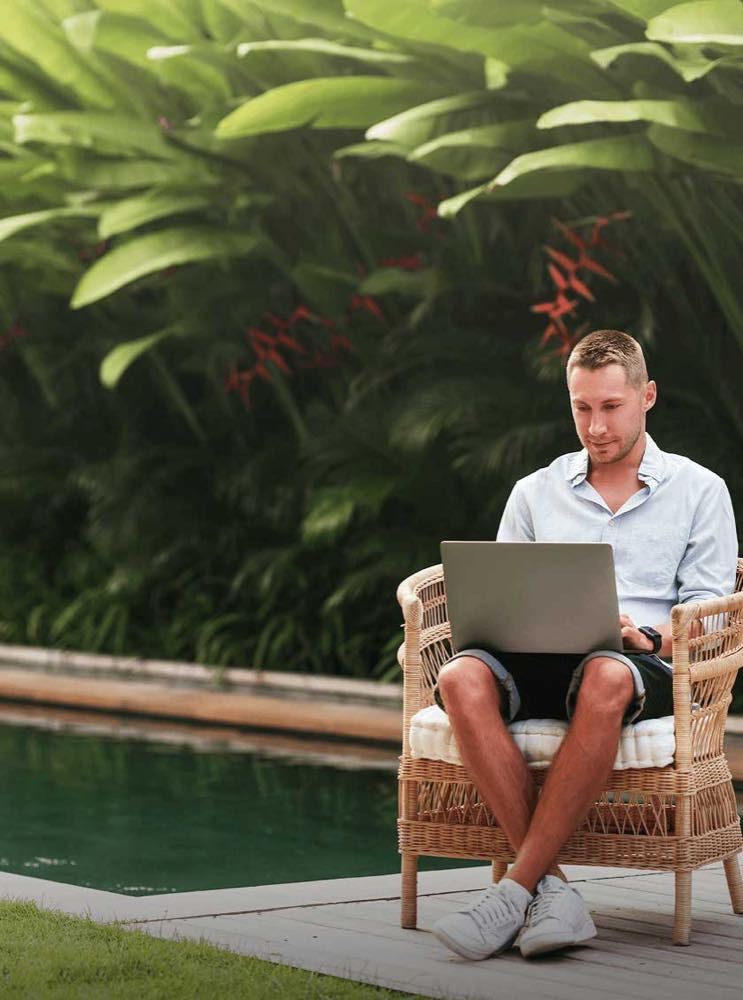 Someone sitting by a pool working through cover options on a laptop